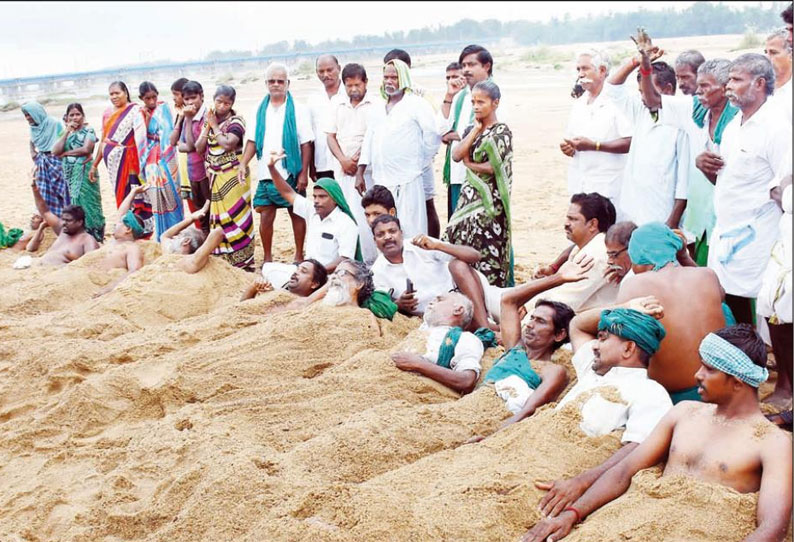 புயலால் பாதிக்கப்பட்டவர்களுக்கு நியாயமான இழப்பீடு கோரி காவிரி ஆற்று மணலில் புதைந்து விவசாயிகள் நூதன போராட்டம்