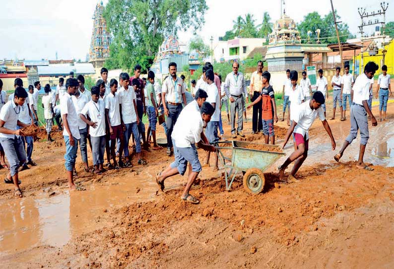 பள்ளிக்கூடம் முன்பு சேறும், சகதியுமான சாலையை சீரமைத்த மாணவர்கள்