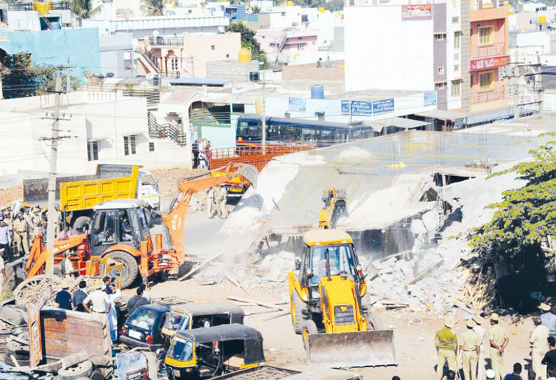 மைசூருவில் அரசு நிலத்தில் கட்டப்பட்ட 15 கடைகள் இடித்து அகற்றம் மாநகராட்சி அதிகாரிகளுடன், வாக்குவாதம்- பரபரப்பு