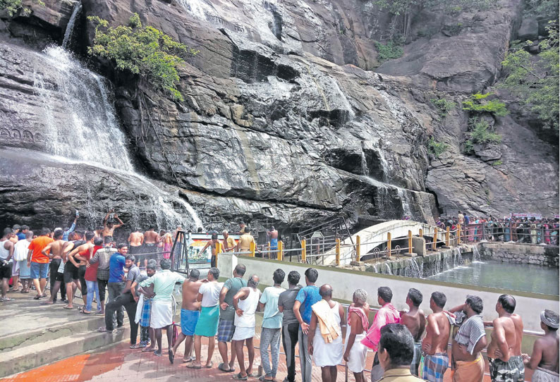 குற்றாலம் அருவிகளில் நீர்வரத்து குறைந்தது சுற்றுலா பயணிகள் வரிசையில் நின்று குளித்தனர்