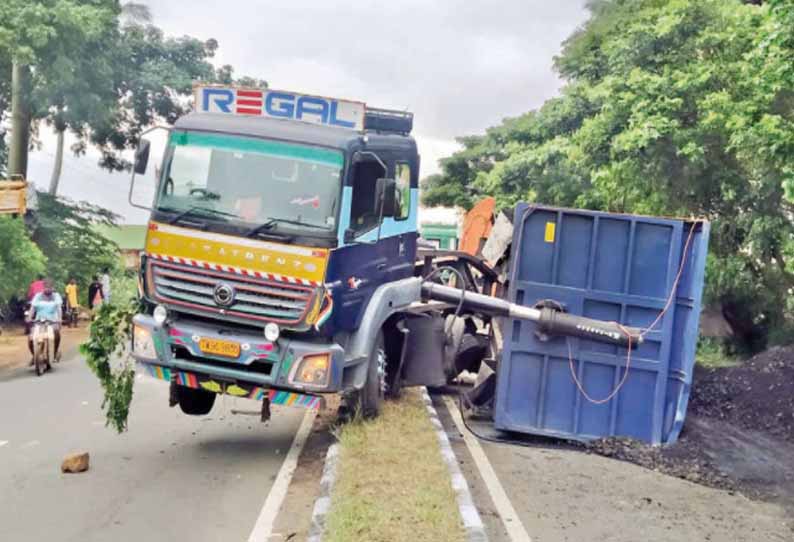 ஆண்டிப்பட்டி அருகே, நிலக்கரி ஏற்றி வந்த கன்டெய்னர் லாரி சாலை தடுப்புச்சுவரில் மோதி கவிழ்ந்தது - போக்குவரத்து பாதிப்பு