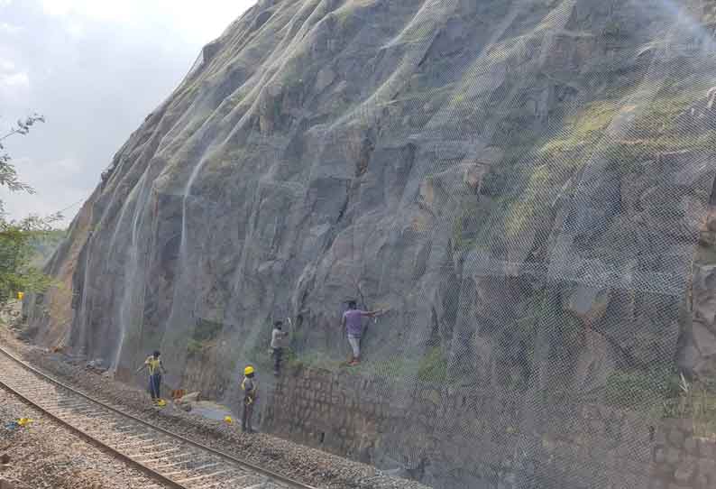 தொப்பூர் அருகே  தண்டவாளத்தில் பாறைகள் விழுவதை தடுக்க மலைப்பகுதியில் கம்பி வலை அமைப்பு