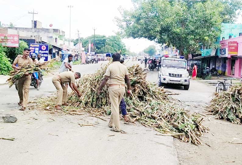 சாலையில் சரிந்து விழுந்த கரும்புகளை அப்புறப்படுத்திய போலீசார்