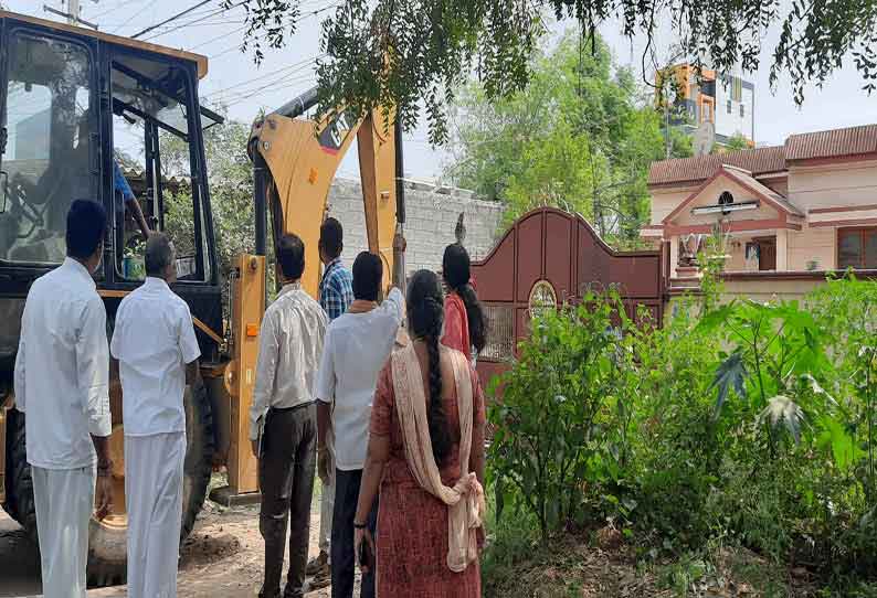 லோகநாதன் வீட்டின் கதவை அதிகாரிகள் பொக்லைன் மூலம் உடைத்த போது எடுத்த படம்.