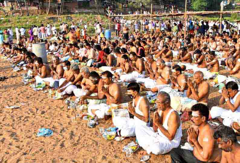 திருப்புவனம் வைகை ஆற்றங்கரையில் அமர்ந்து முன்னோர்களுக்கு தர்ப்பணம் செய்பவர்களை படத்தில் காணலாம்.