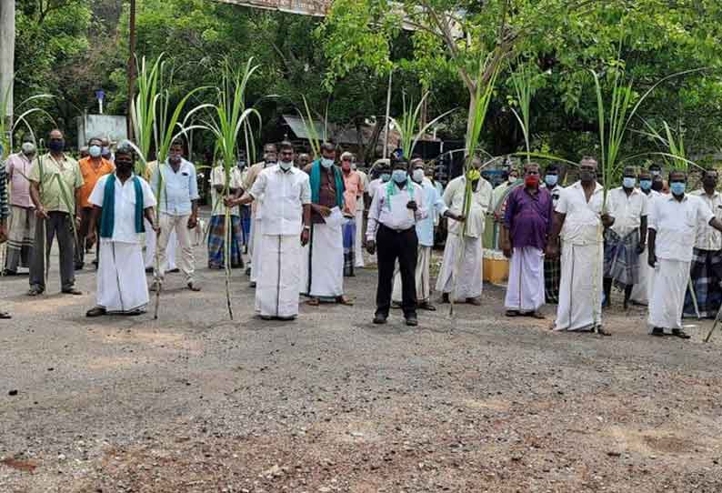 கரும்பை கையில் பிடித்து விவசாயிகள் ஆர்ப்பாட்டம்