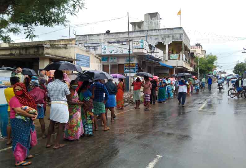 அந்தியூரில், கொரோனா நிவாரண நிதி வாங்க கொட்டும் மழையிலும் குடை பிடித்தபடி நீண்ட வாிசையில் காத்து நின்ற பொதுமக்கள்