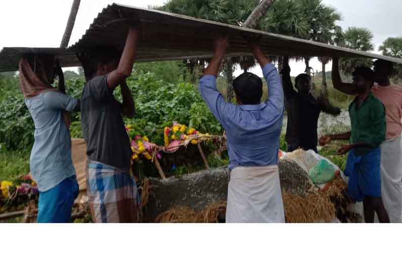 கொட்டும் மழையில் தகரத்தை பிடித்தபடி பிணத்தை எரித்த அவலம்