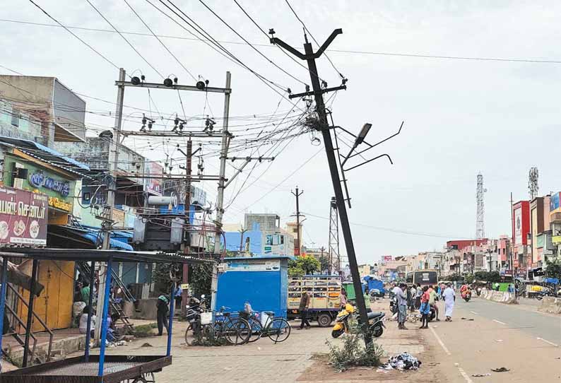 கும்மிடிப்பூண்டி பஜார் நடைபாதையில் சாய்ந்த நிலையில் ஆபத்தாக காட்சியளிக்கும் மின்கம்பம்