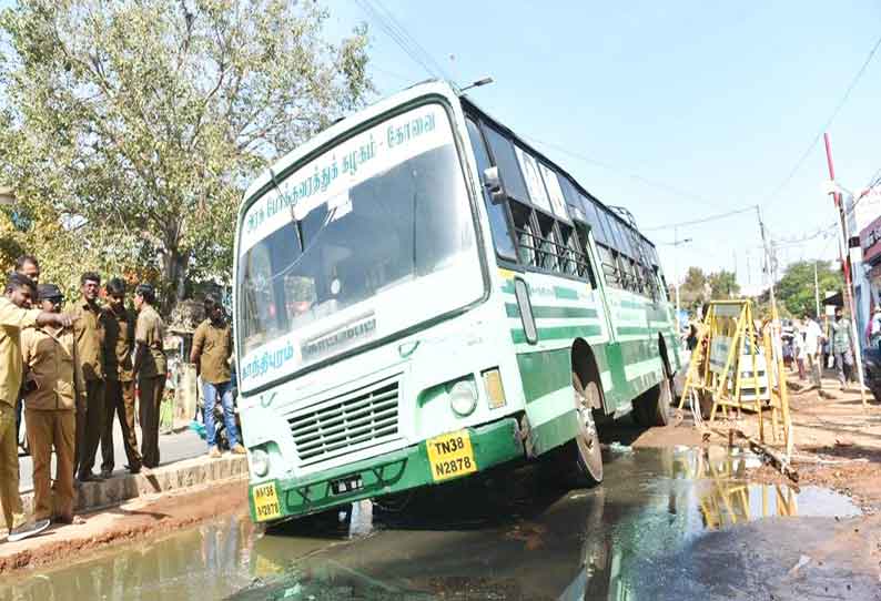 கோவை ரெயில் நிலையம் முன்பு கழிவுநீர் பள்ளத்தில் சிக்கிய அரசு பஸ்