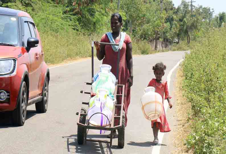 தண்ணீருக்காக குழந்தையுடன் செல்லும் பெண்