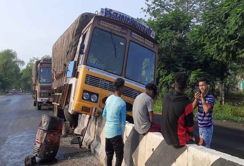 சத்தியமங்கலம் அருகே  ரோட்டின் நடுவில் வைக்கப்பட்டிருந்த தடுப்பு சுவரில் லாரி மோதியது; டிரைவர்- கிளீனர் உயிர் தப்பினர்