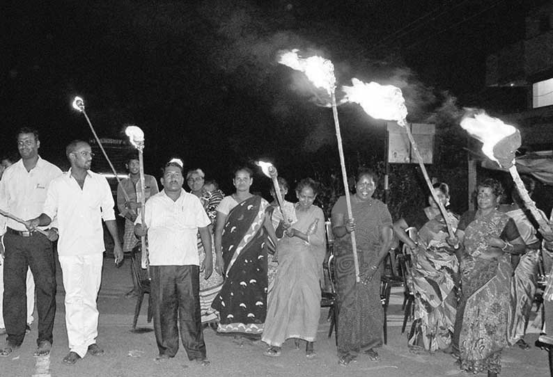 மின்விளக்குகளை எரிய விடக்கோரி தீப்பந்தங்களை ஏந்தியபடி போராட்டம்