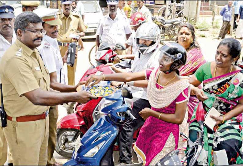 ஹெல்மெட் அணிந்து சென்றவர்களை போலீசார் இனிப்பு வழங்கி பாராட்டினர்