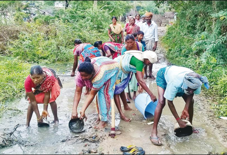 அதிகாரிகள் சீர் செய்யாததால் சாலையில் தேங்கிய சேற்றை அகற்றி மாதர் சங்கத்தினர் போராட்டம்